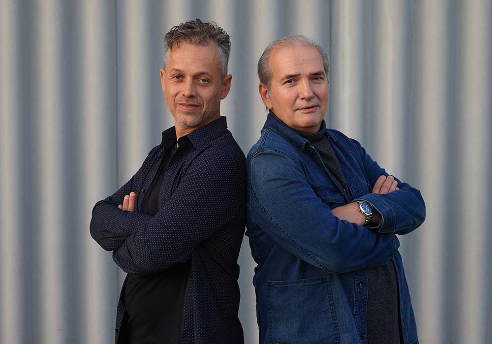 Daniel Steger und Thomas Götz vor einer grauen Gebäude-Fassade